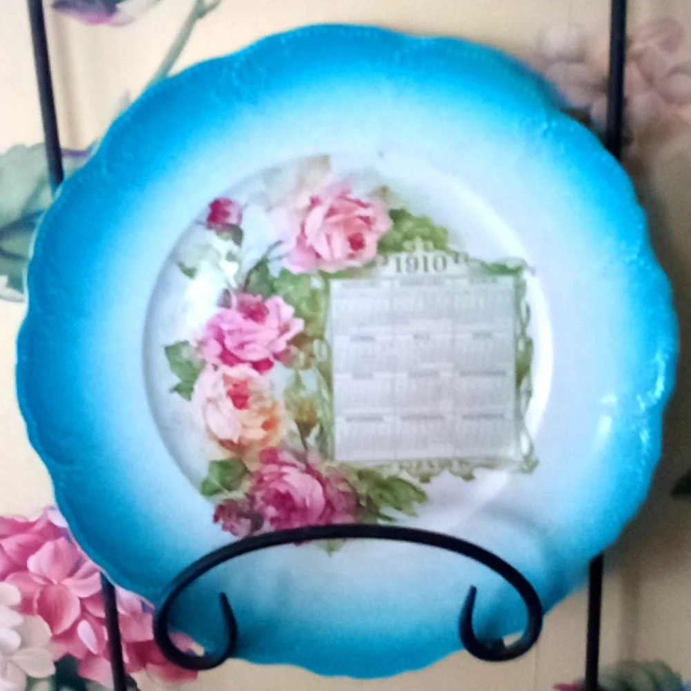 Hand painted calendar advertising plate from 1910. Turquoise & roses